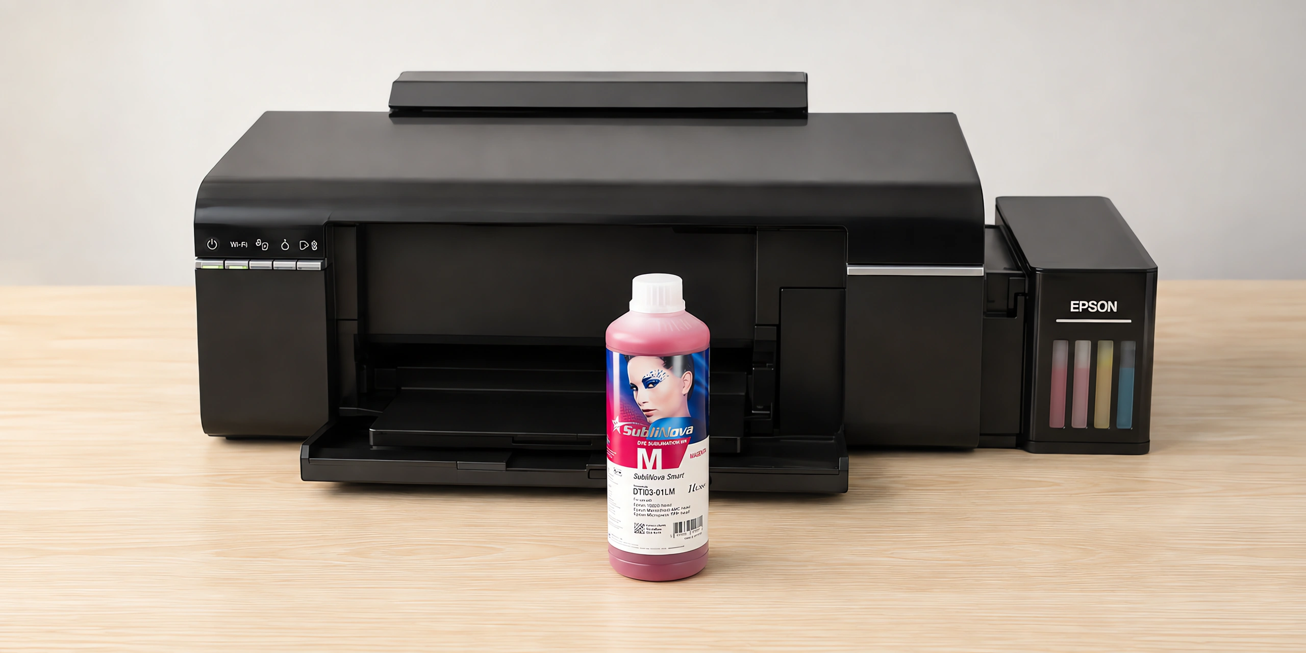 Tinta para sublimar Inktec, Epson serie L en su envase magenta, sobre la mesa de trabajo, con la impresora que la usa detrás