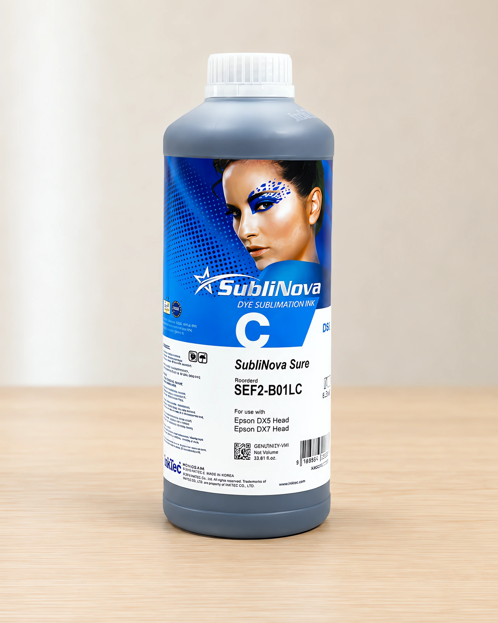 Tinta para sublimar de gran formato en su envase cyan con chip, sobre la mesa de trabajo