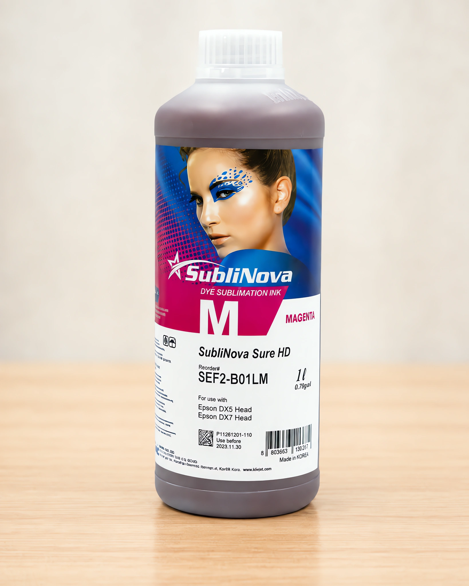 Tinta para sublimar de gran formato en su envase magenta, sobre la mesa de trabajo