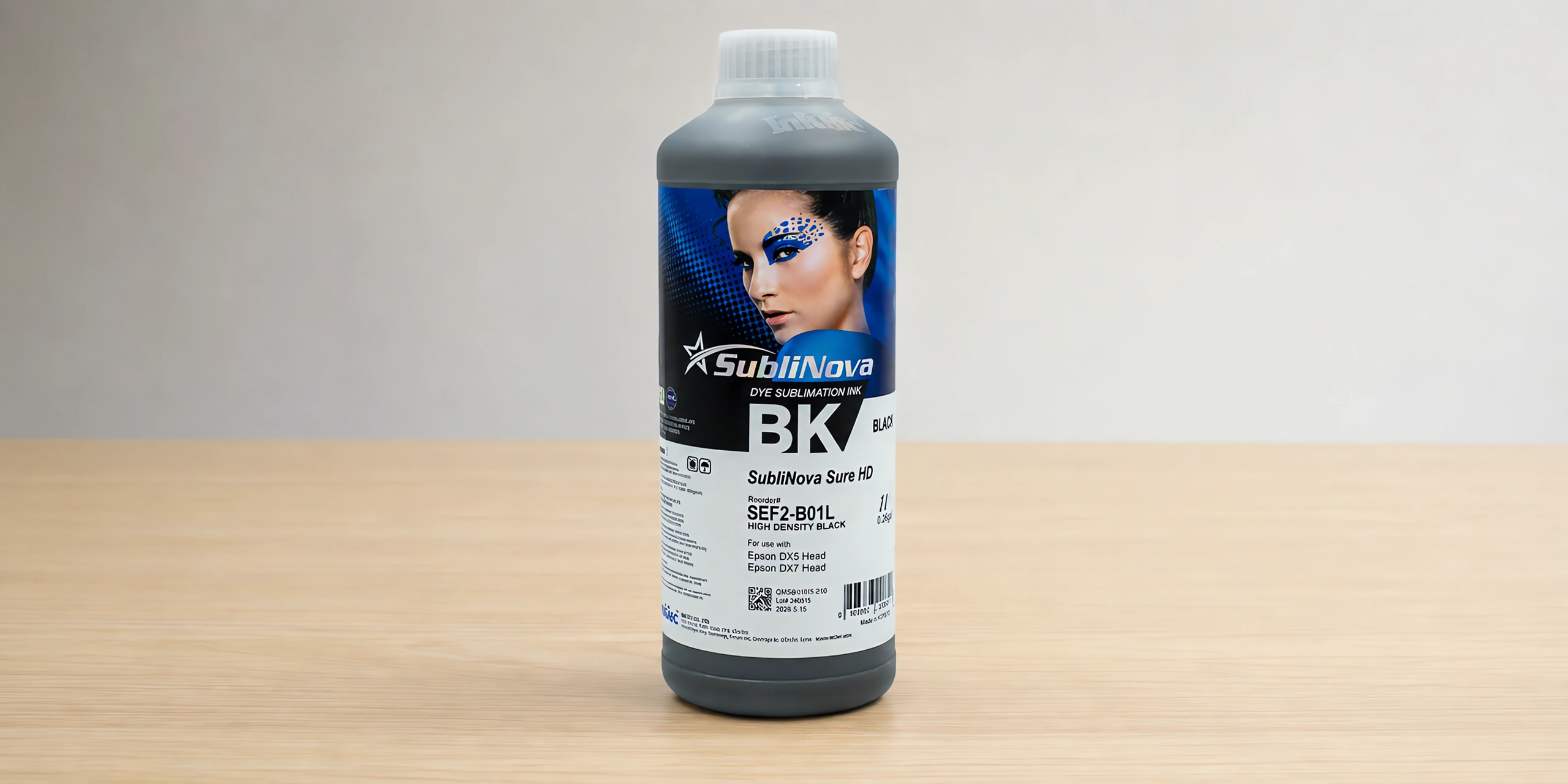 Tinta para sublimar de gran formato en su envase negro hdk, sobre la mesa de trabajo