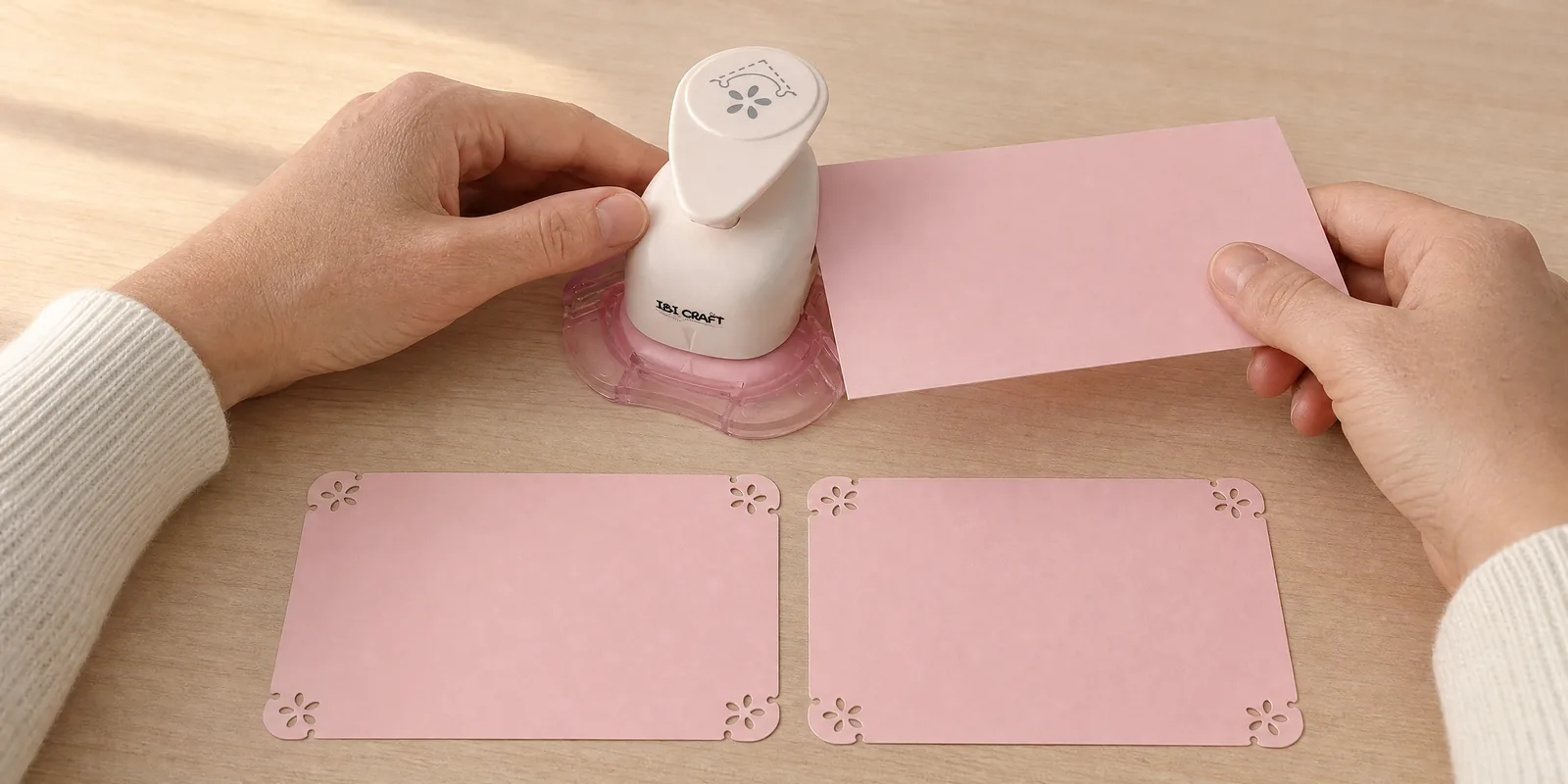 Manos usando el esquinero daisy, con dos tarjetas ya caladas delante